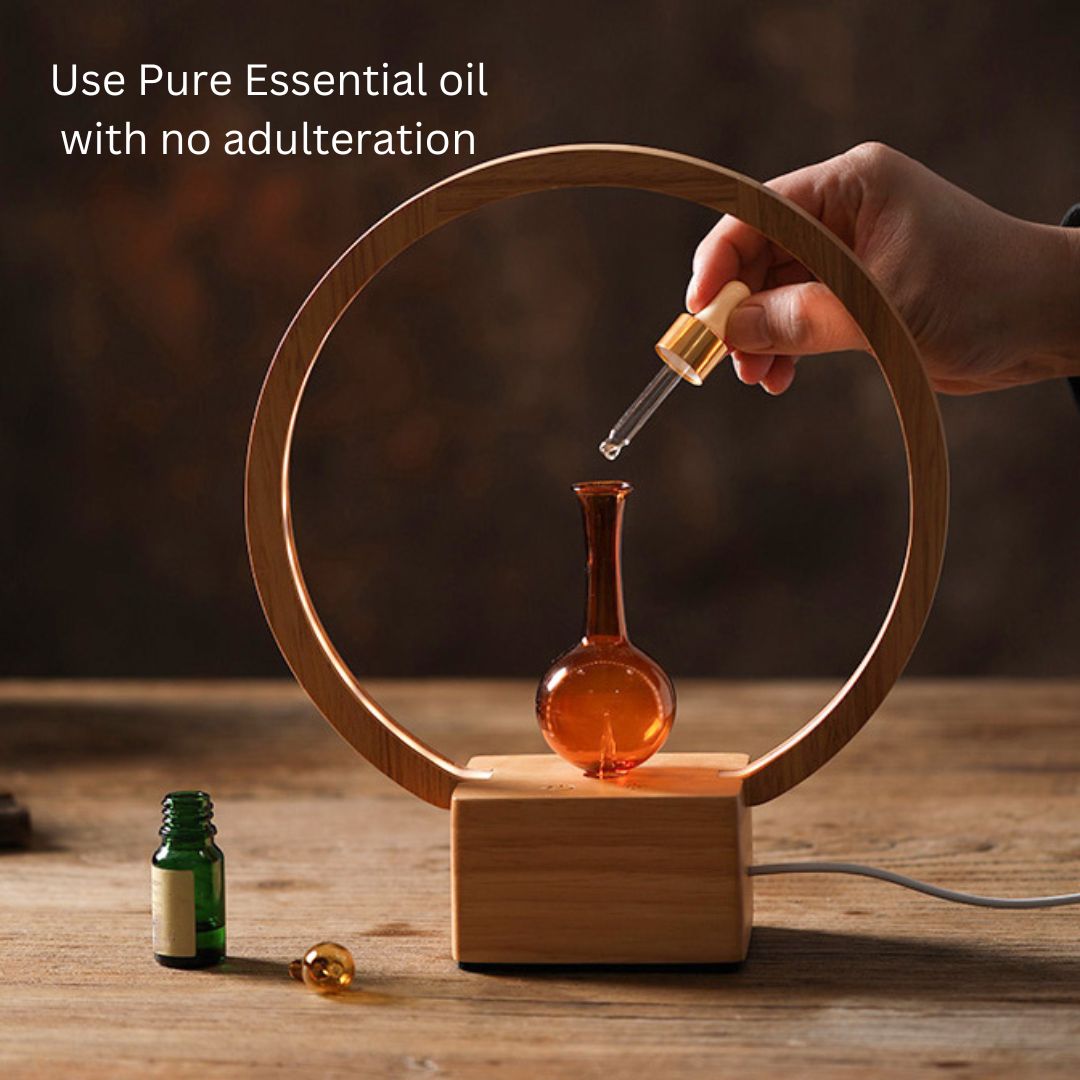 Hand using a dropper to add essential oil into a wooden lamp with text about pure essential oils.